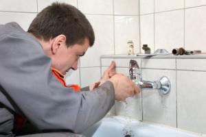 a technician fixes a leaky bathtub spout